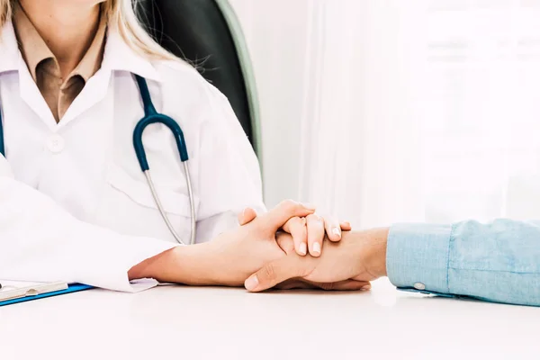Ärztin Berät Und Hält Männliche Patientin Beruhigend Der Hand Auf — Stockfoto