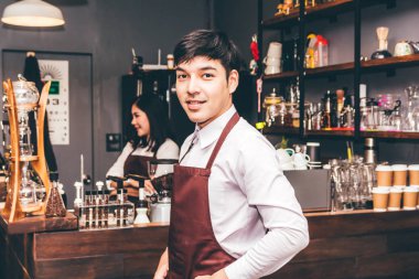 Gülümseyen ve arkasında, bir kafede sayaç bar yakışıklı barista portresi