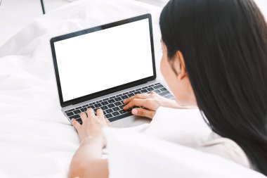 Rahatlatıcı ve sosyal uygulamalar kontrol ve smartphone ile çalışan home.woman, yatağa dijital dizüstü bilgisayar kullanan mutlu kadın