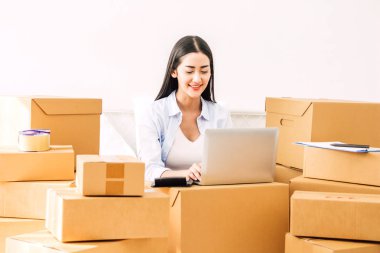 Genç kadın bağımsız çalışma ve kullanım dizüstü bilgisayar ile karton kutu yatağa evde - KOBİ iş online ve teslimat kavramı