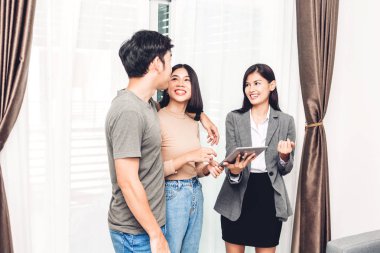 Emlakçı tutan tablet ve Genç çift Satılık bir ev ile konuş. iş ve ev kavramı