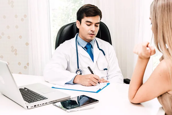 Doctor consulting and check up information with female patien on doctors table in hospital.healthcare and medicine