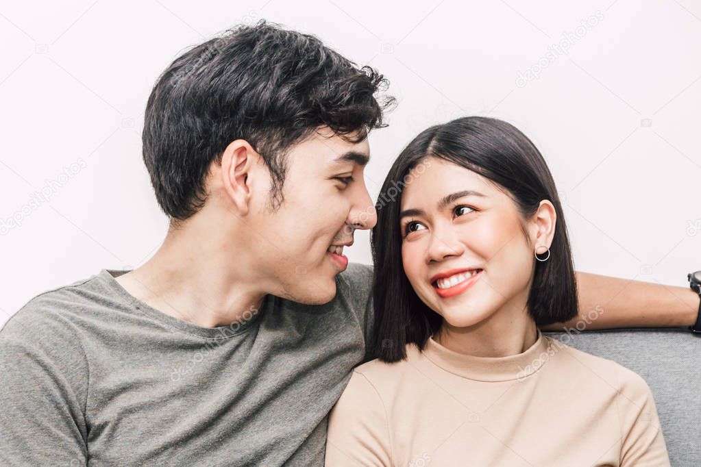 Happy couple sitting on sofa at home