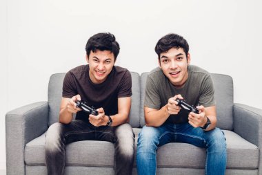 Kanepede oturan ve zevk iki arkadaş birlikte evde video oyunu oynamak