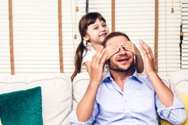 Babası ile eğleniyor ve home.little kız kanepede yakından baba oynarken küçük kızı babasının sürpriz. Gün kavramı, Aile ve baba sevgisi