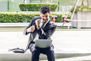 Siyah şık elbiseli kadar silah ile kutluyor ve dizüstü bilgisayar ile şehrin üzerinde çalışma otururken yakışıklı işadamı başarılı. İş ve başlangıç fikir kavramı