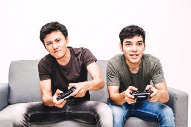 Kanepede oturan ve zevk iki arkadaş birlikte evde video oyunu oynamak