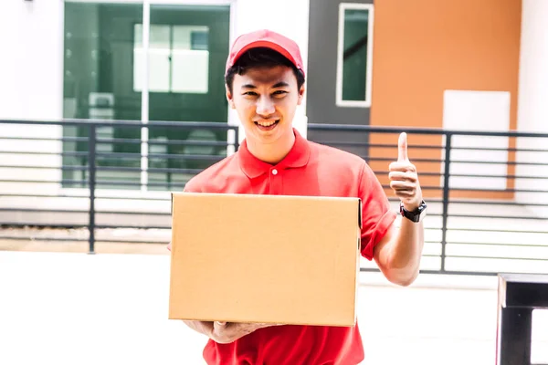 Happy Smiling Delivery Man Red Uniform Show Thumb Holding Parcel — Stock Photo, Image