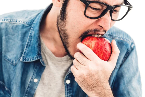 Handsome man eating and biting red apple. Healthy natural food concept