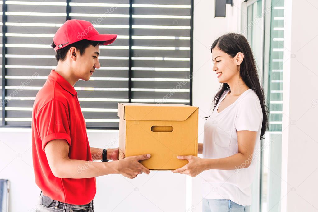 Woman accepting a delivery boxes from delivery man in red uniform.courier service concept
