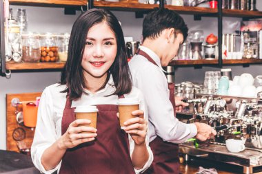Gülümseyen ve bir kafede kahve sayaç barın arkasında tutarak kadın küçük işletme sahibi portresi. Kafede kahve makinesi kullanarak çift barista