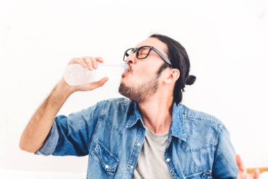 Evde taze duygu ve rahatlatıcı bir şişe içme suyu sağlıklı genç adam