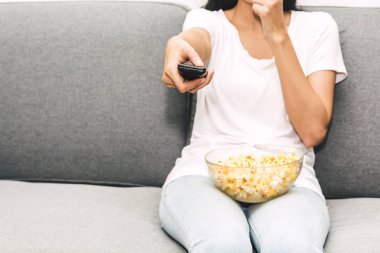 Patlamış mısır yemek ve evde kanepede televizyon izlerken kadın