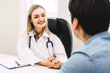 Danışmanlık ve doktorlar tablosundaki hospital.healthcare ve tıp el erkek hasta bakımı ile güven verici tutan kadın doktor