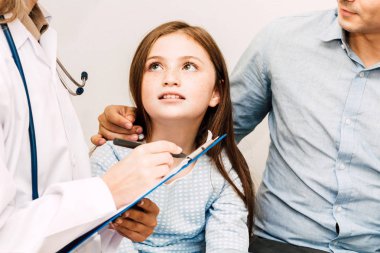 Danışmanlık doktor ve hastanede küçük kızla bilgilerini kontrol edin. Küçük bir kız sick.healthcare ve tıp vardır