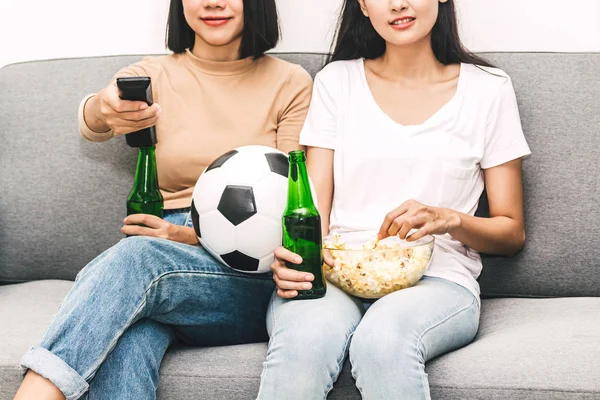 人の女性友人がポップコーンを食べ ビールを一緒に飲むと自宅のソファでサッカーの試合を見てします 友情とパーティーのコンセプト — ストック写真