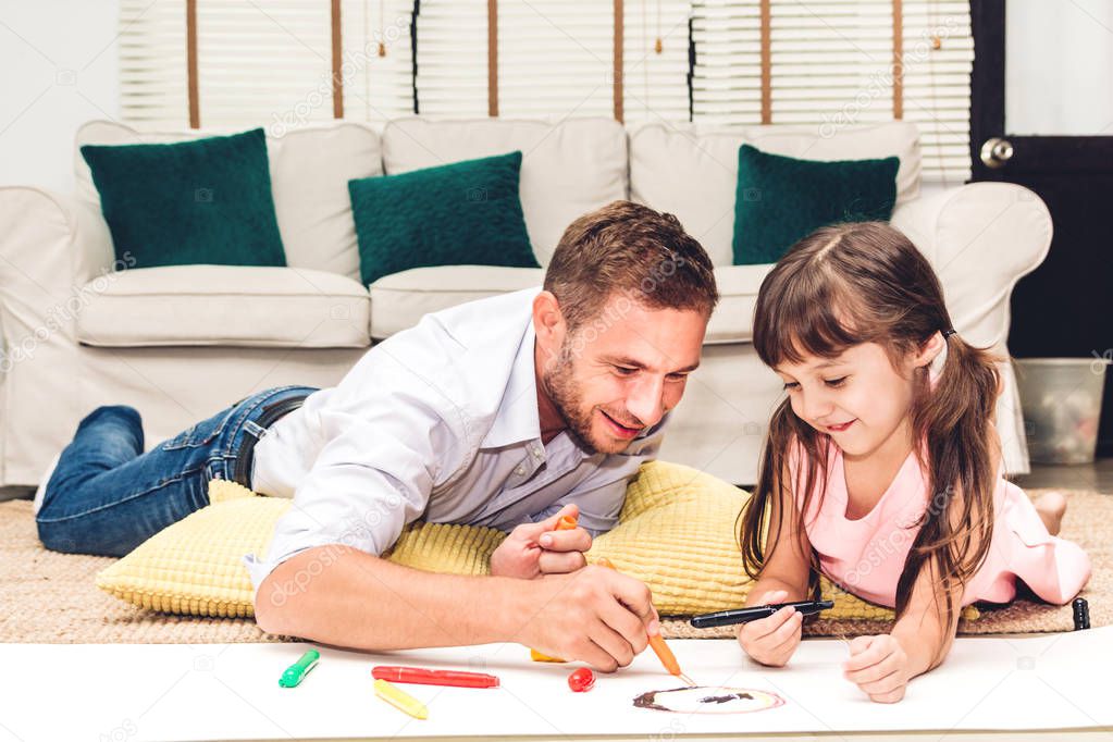 Father with little daughter having fun and do her homework at home.painting and drawing.Love of family and father day concept