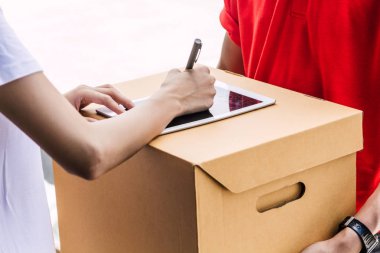 İmza tablet karton kutu üzerinde alıcı pakete kırmızı uniform.courier hizmet anlayışı içinde teslim adamla koyarak kadın