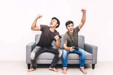 Kanepede oturan ve zevk iki arkadaş birlikte evde video oyunu oynamak