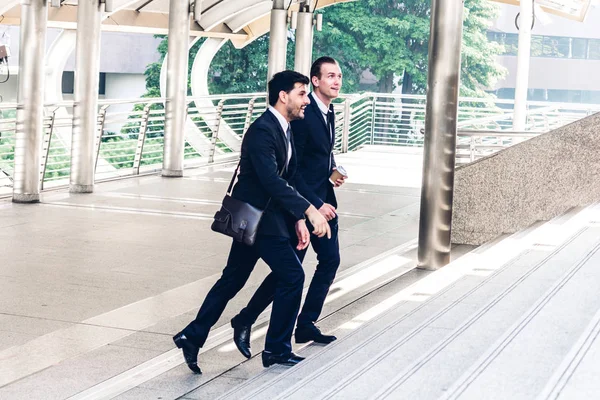 Dos Compañeros Trabajo Sonrientes Negocios Traje Negro Hablando Caminando Gente — Foto de Stock