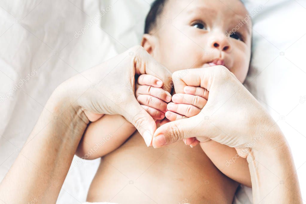 Newborn baby hand on mother hands