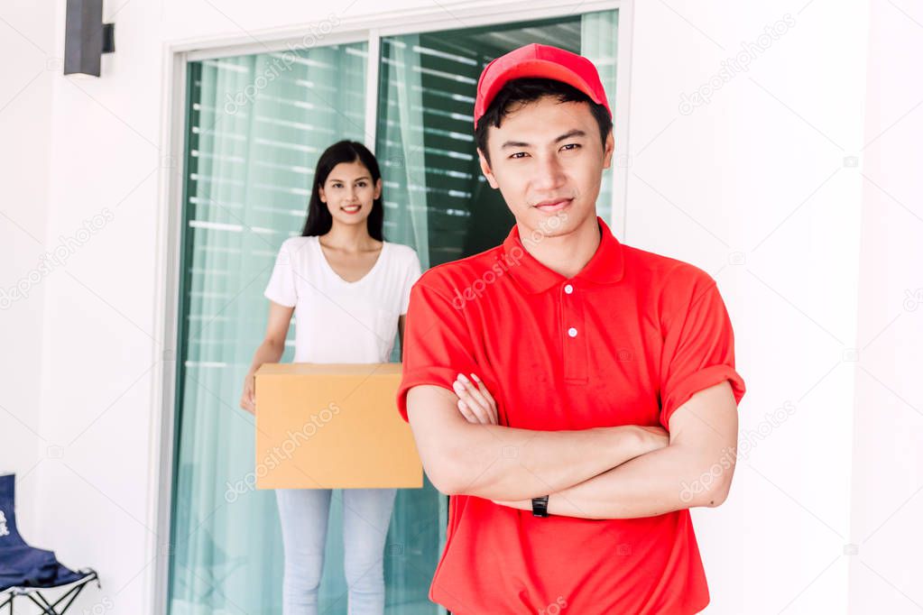Woman accepting a delivery boxes from delivery man in red uniform.courier service concept