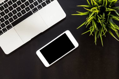 Siyah arka plan üzerine üstten görünüm dizüstü bilgisayar ve mockup Smartphone ile boş perde. Düz yatıyordu