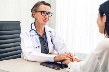 Danışmanlık ve doktorlar tablosundaki hospital.healthcare ve tıp el hasta bakımı ile güven verici tutan kadın doktor