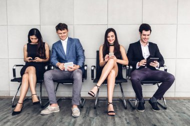 Grup iş oturan rahat kullanımı teknoloji sosyal uygulamalar kontrol ve duvar background.Communication kavramı üzerinde çalışma birlikte smartphone ve tablet bilgisayar