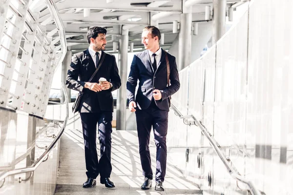 Dos Compañeros Trabajo Sonrientes Negocios Traje Negro Hablando Caminando Gente — Foto de Stock