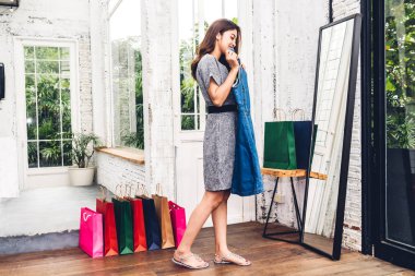 Alışveriş ve konsept alışveriş store.fashion aynada isteyen giysiler seçmek mutlu kadın