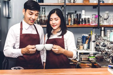 Gülümseyen ve bir kafede sayaç barın arkasında çalışan çift küçük işletme sahibi portresi. Çift barista kahve makinesi kahve café'de yapmak için kullanma