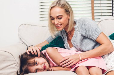 Eğleniyor ve anne ile evde kanepede oynarken küçük kızı annesiyle. Gün kavramı, Aile ve baba sevgisi