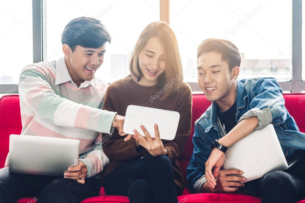 Group of business sitting relax use technology together of smartphone and laptop computer checking social apps and working on brick wall background.Communication concept