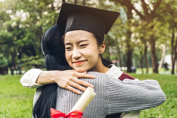 Successful of student young woman and bachelor gowns with diplomas graduate hugging her friend at university.Celebrating graduation and education concept