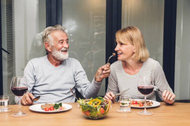 Üst düzey çift yemek yemek ve içki şarap bardakları birlikte evde mutfakta rahatlayın. Emeklilik çift kavramı