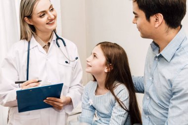 Danışmanlık doktor ve hastanede küçük kızla bilgilerini kontrol edin. Küçük bir kız sick.healthcare ve tıp vardır