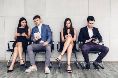Grup iş oturan rahat kullanımı teknoloji sosyal uygulamalar kontrol ve duvar background.Communication kavramı üzerinde çalışma birlikte smartphone ve tablet bilgisayar