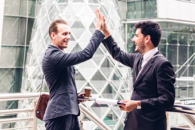 Successful business team giving a high fives gesture at city background