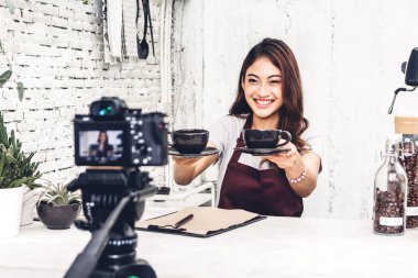 Kadın barista blogger kendini bir kafede sayaç barın arkasında kayıt kamera önünde portresi