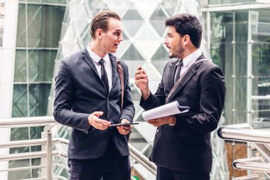 Siyah gülümseyen iki işadamı iş arkadaşlarınızla konuşmak ve walking.business insanlar modern kent strateji tartışmaya uygun
