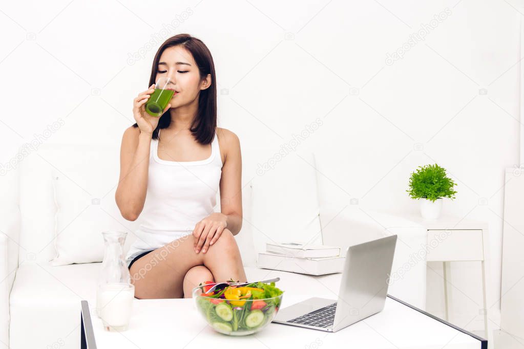 Woman enjoy healthy drinking green detox vegetable juice in the living room at home.dieting concept.healthy lifestyle