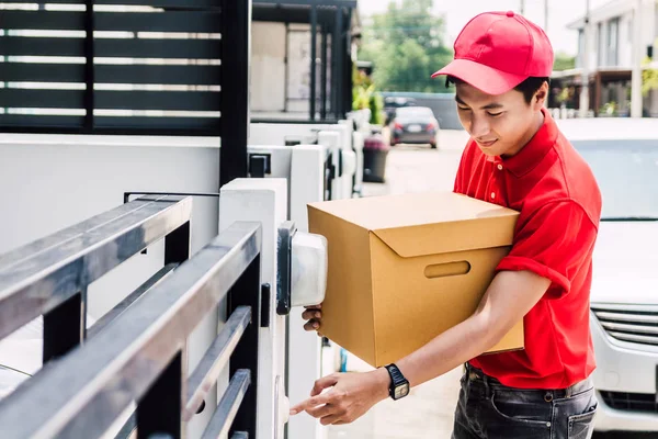 Felice Uomo Consegna Uniforme Rossa Contenente Scatola Cartone Piedi Vicino — Foto Stock