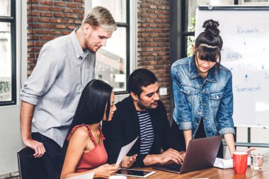 Geçici iş tartışırken grup ve dizüstü computer.creative iş ile çalışma planlama insan ve modern workloft beyin fırtınası. Ekip çalışması kavramı