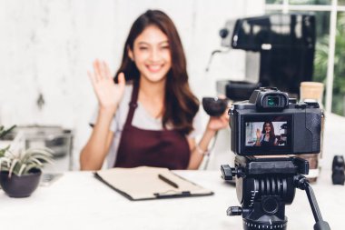 Kadın barista blogger kendini bir kafede sayaç barın arkasında kayıt kamera önünde portresi