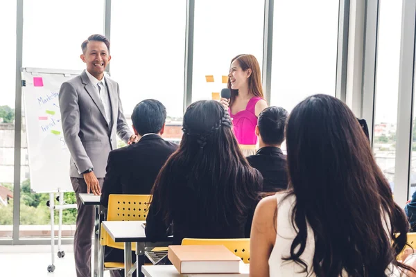 Salon veya seminer odasındaki danışmanlık konferansı seminerinde bir grup insanın önünde duran iş adamı. Sunum ve koçluk konsepti