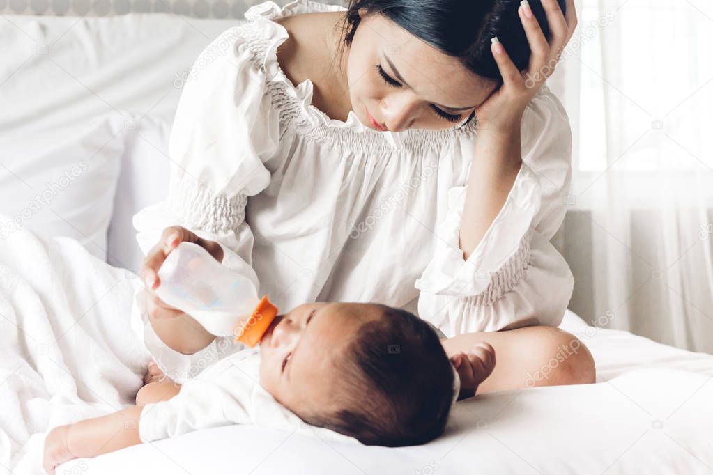 Mother feeding baby from milk bottle