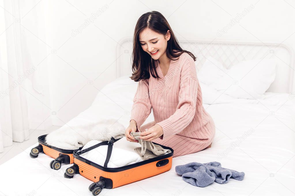 Woman packing a suitcase luggage and backpack for travel at home.Holiday vacation concept