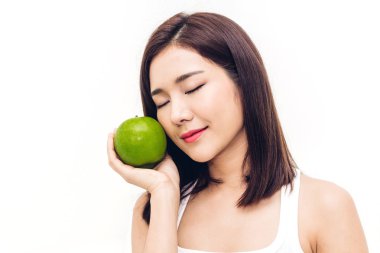 Beyaz arka planda taze yeşil elma tutan ve yiyen bir kadın. Diyet konsepti. Sağlıklı yaşam tarzı.