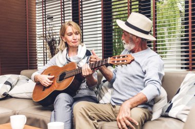 Yaşlı çift evdeki oturma odasında kanepede oturup sohbet ediyor. Emekliler konsepti.